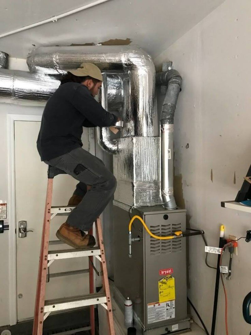 Technician cleaning a furnace in a Brooklyn home