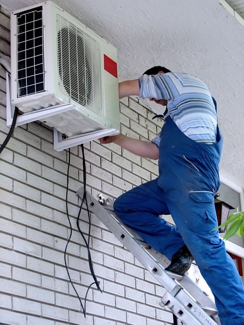 Technician cleaning an AC coil in a Brooklyn home