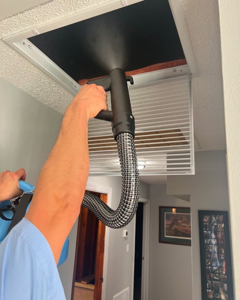 Technician cleaning HVAC system components in a Brooklyn home